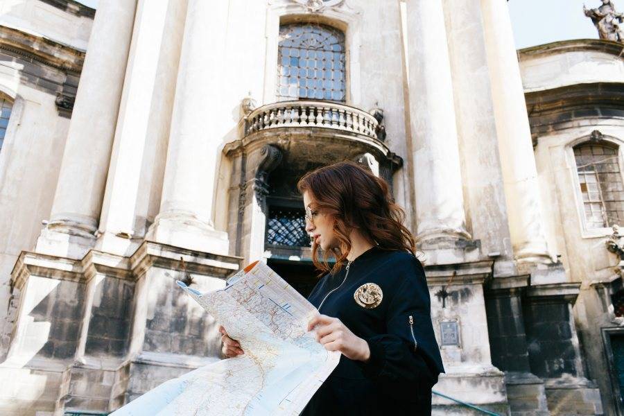 Person reading a map in front of a historical building