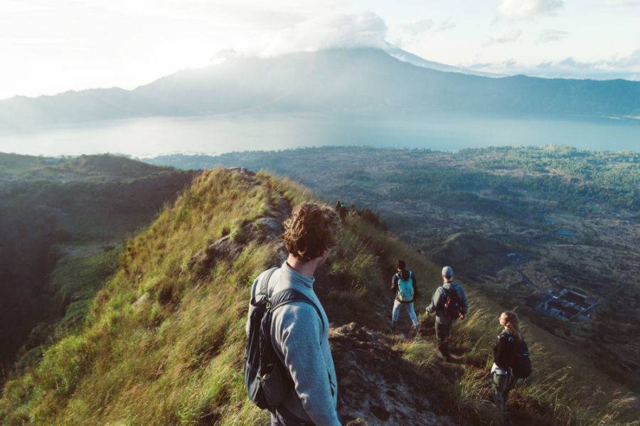 people hiking grassy mountain