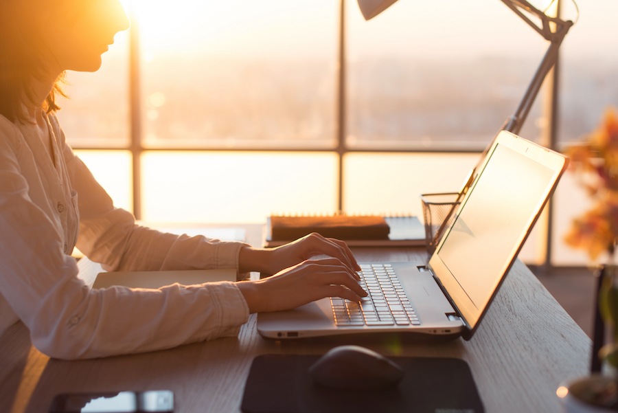 Person using computer in the sunset