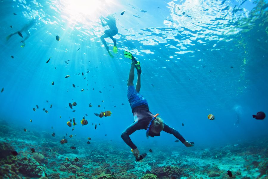 man snorkelling in cerulean blue waters