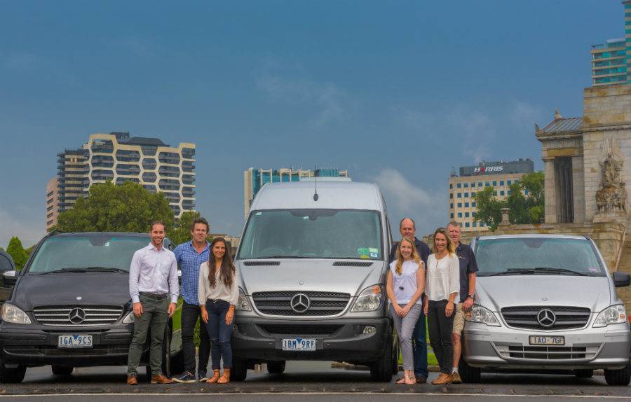 Tour business team standing with tour vehicles for Melbourne tours.
