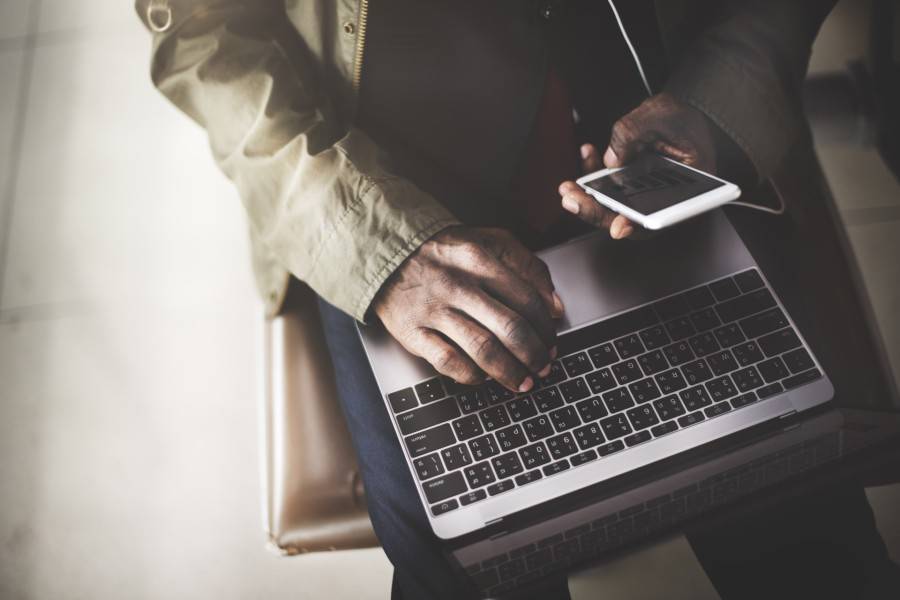 Person using a laptop and a mobile device