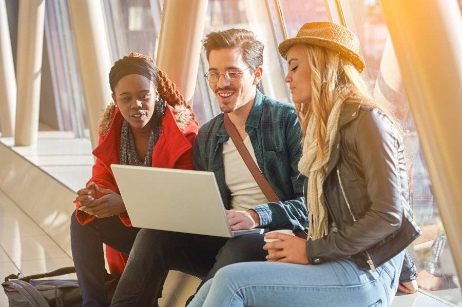 A group of friends collaborating on a laptop