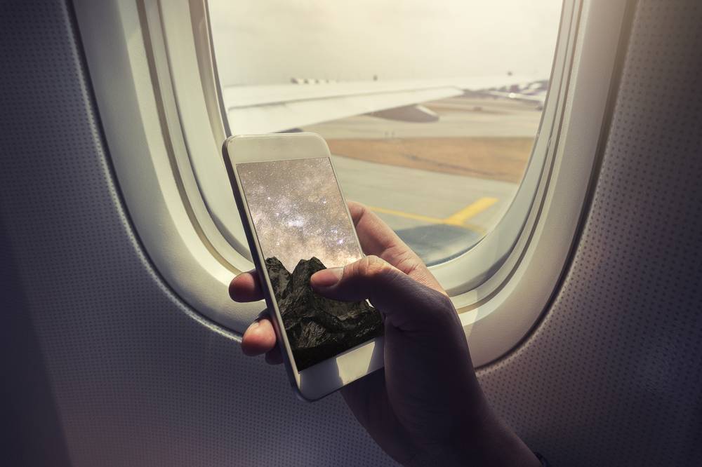 Someone using a mobile device on an aeroplane