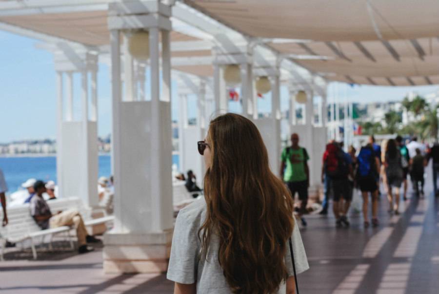 Girl walking along ocean path in a warm destination