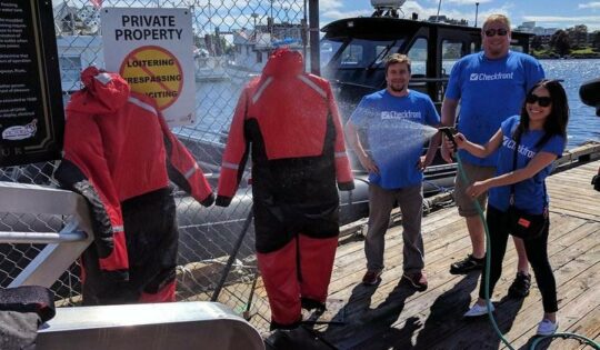 Checkfront employee spraying wetsuit