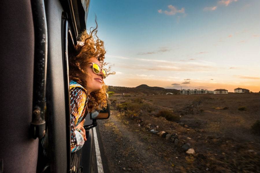 Woman leaning out of window with wind in her hair