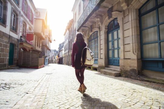 Tourist walking down a cobble stone road