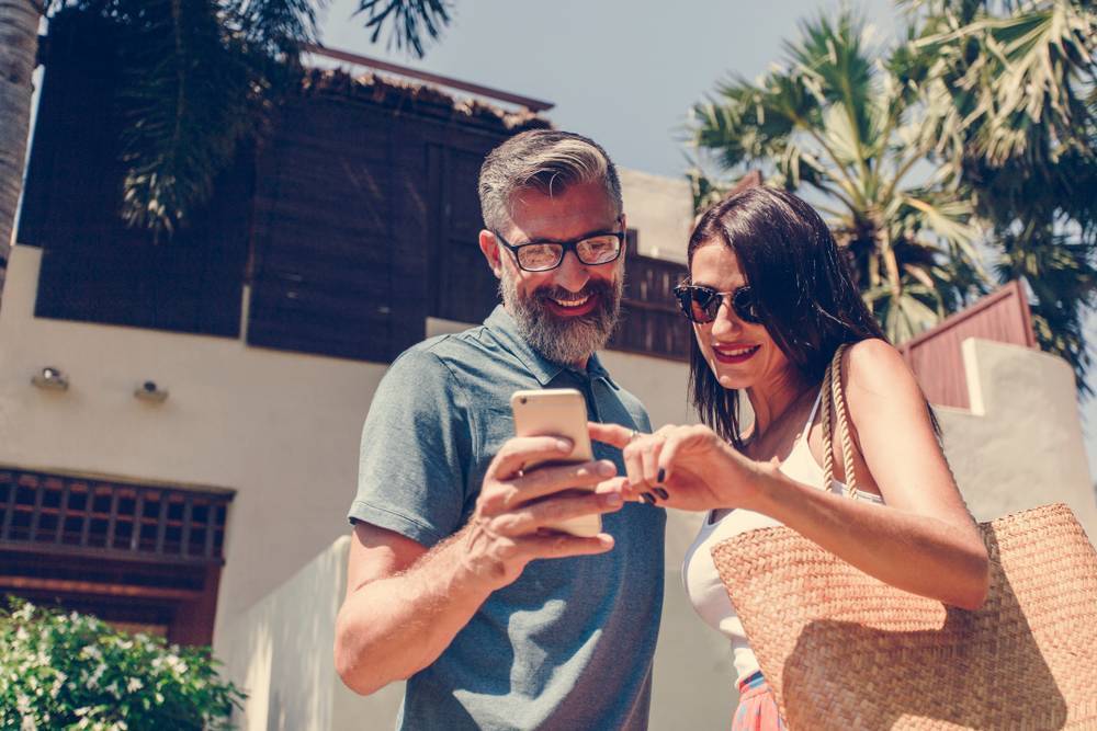 People smiling while looking at their smartphone