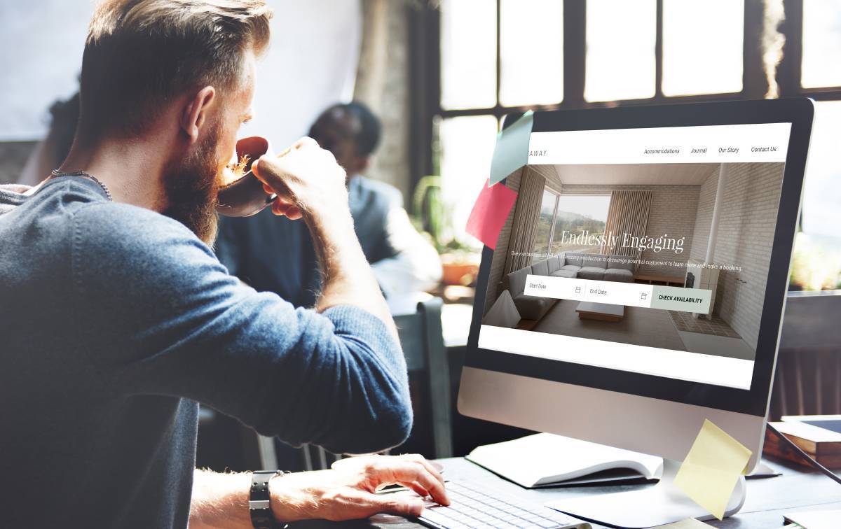 Man drinking coffee sitting at desktop computer