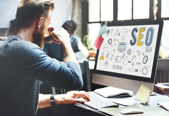 Guy sipping coffee at desk looking at an seo computer screen