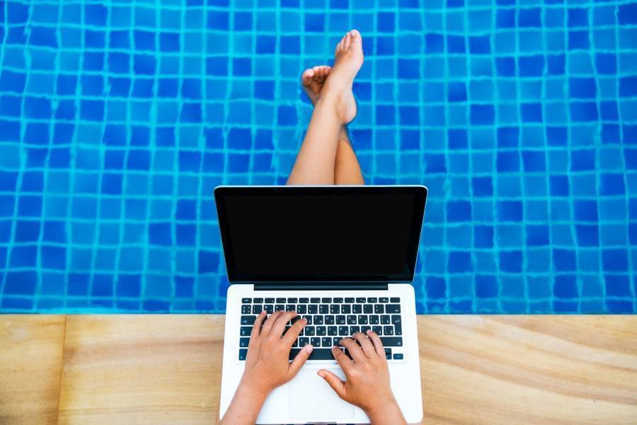 Person using a laptop at the pool