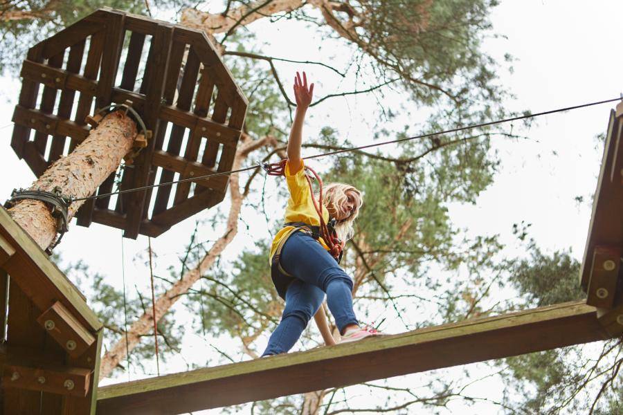 A person using a ropes course in the trees