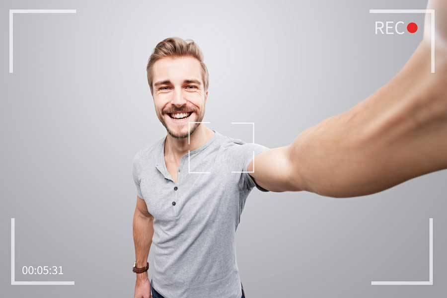 Recording screenshot of male doing a selfie video testimonial against grey wall.