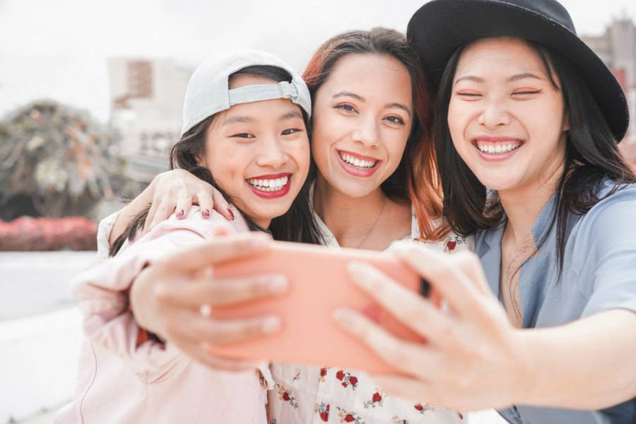 Group of three asian girls taking a selfie for social media