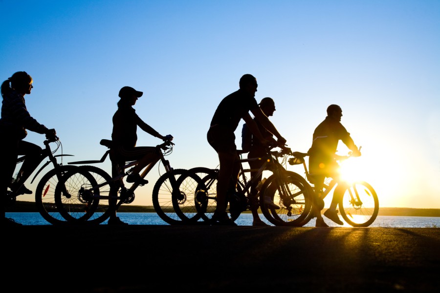 Group of cyclists driving at sunset, starting a local collective.