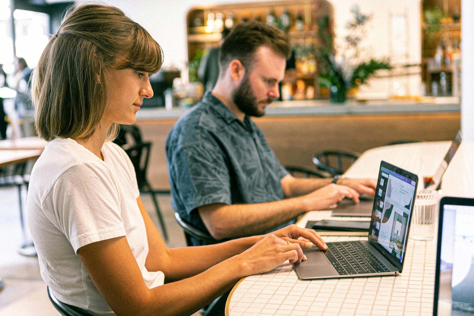 Photo Of Woman Using Laptop with a guy at the background