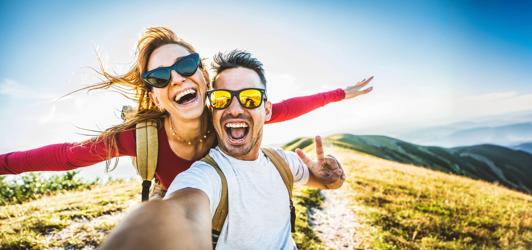 Happy travelers capturing a moment of joy on a mountain trail