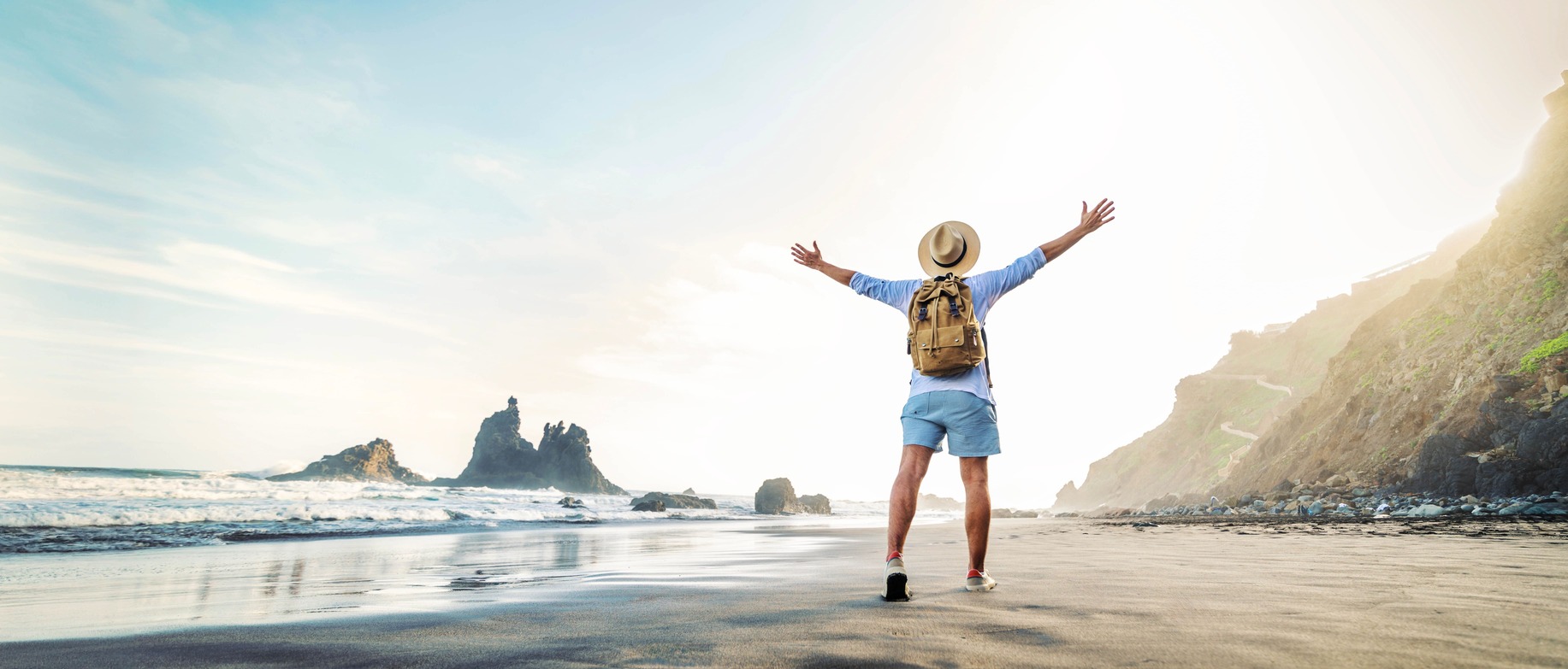 Tourist enjoying a scenic beach view, symbolizing the freedom and flexibility provided by the best tour operator software.