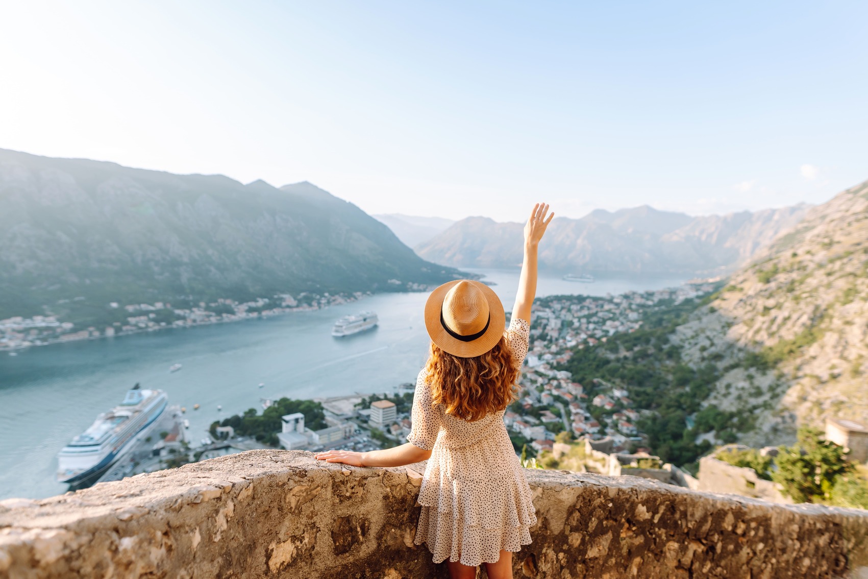 Traveler enjoying a panoramic view of a bay and mountains