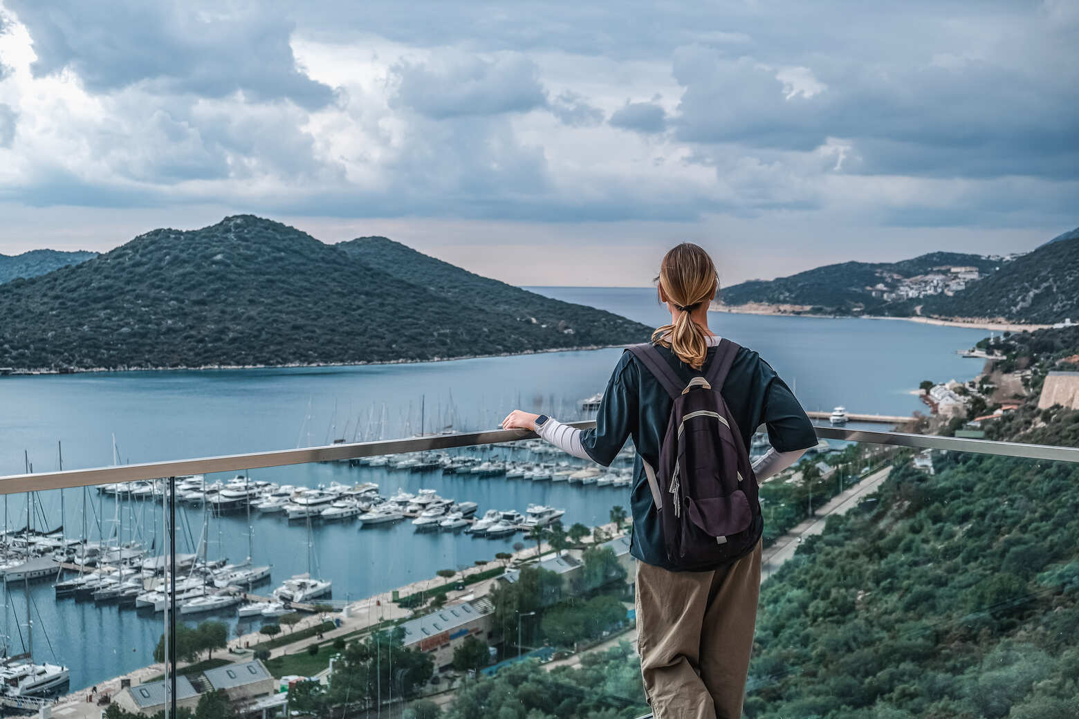 Woman admiring a marina and scenic landscape